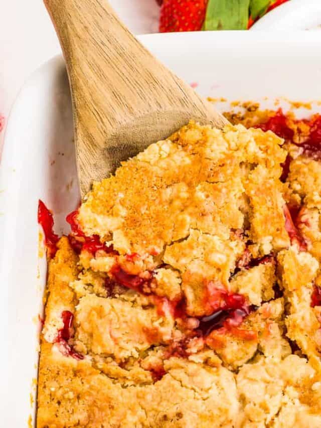 a spoon taking out a scoop of strawberry dump cake