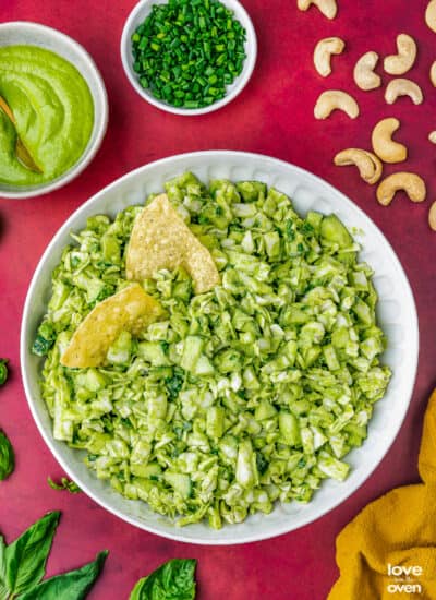 two tortilla chips in a batch of green goddess salad