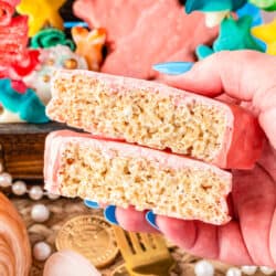 a hand holding a star shaped rice krispie treat that has been cut in half