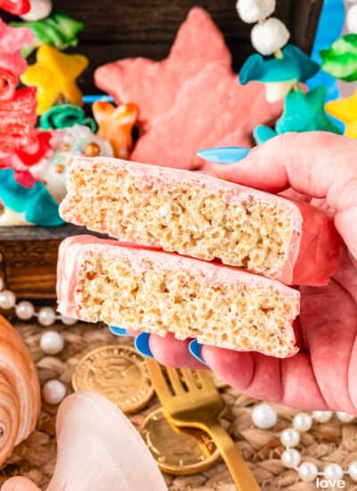 a hand holding a star shaped rice krispie treat that has been cut in half