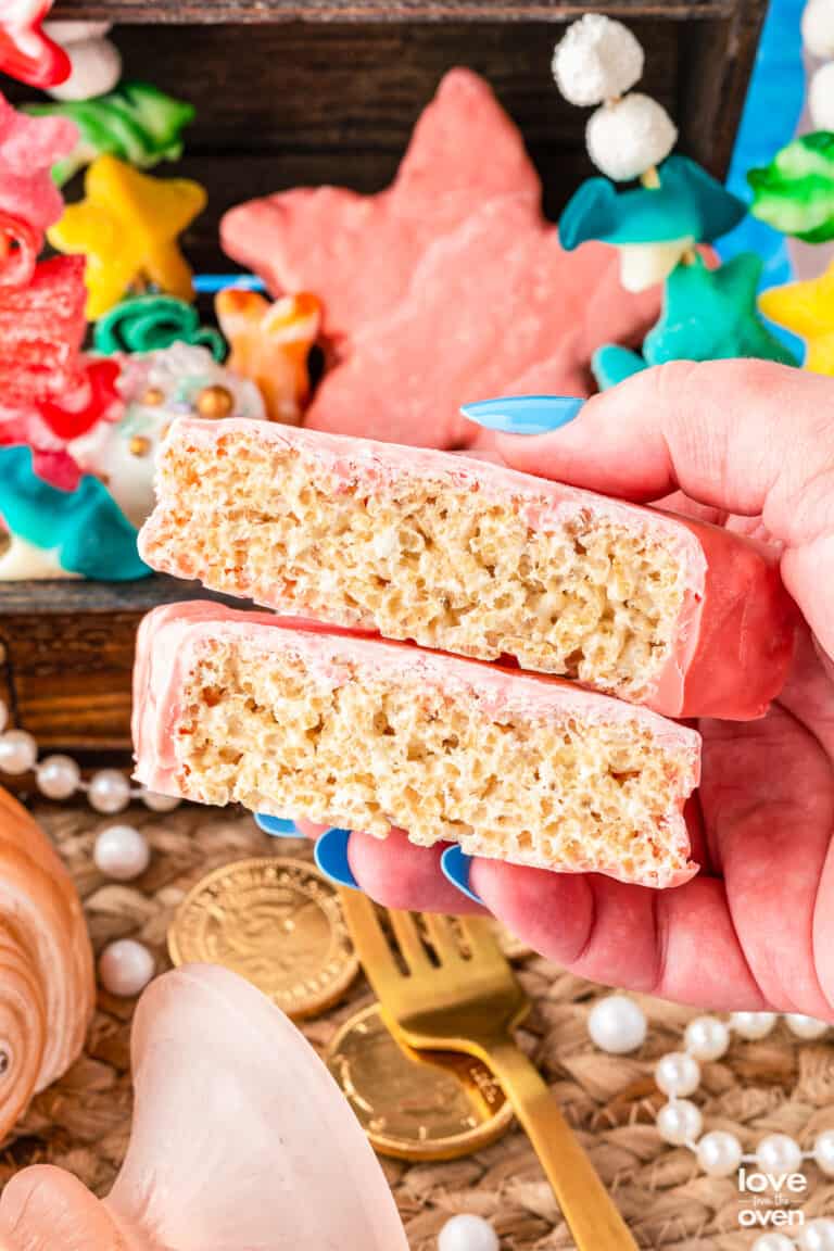 a hand holding a star shaped rice krispie treat that has been cut in half