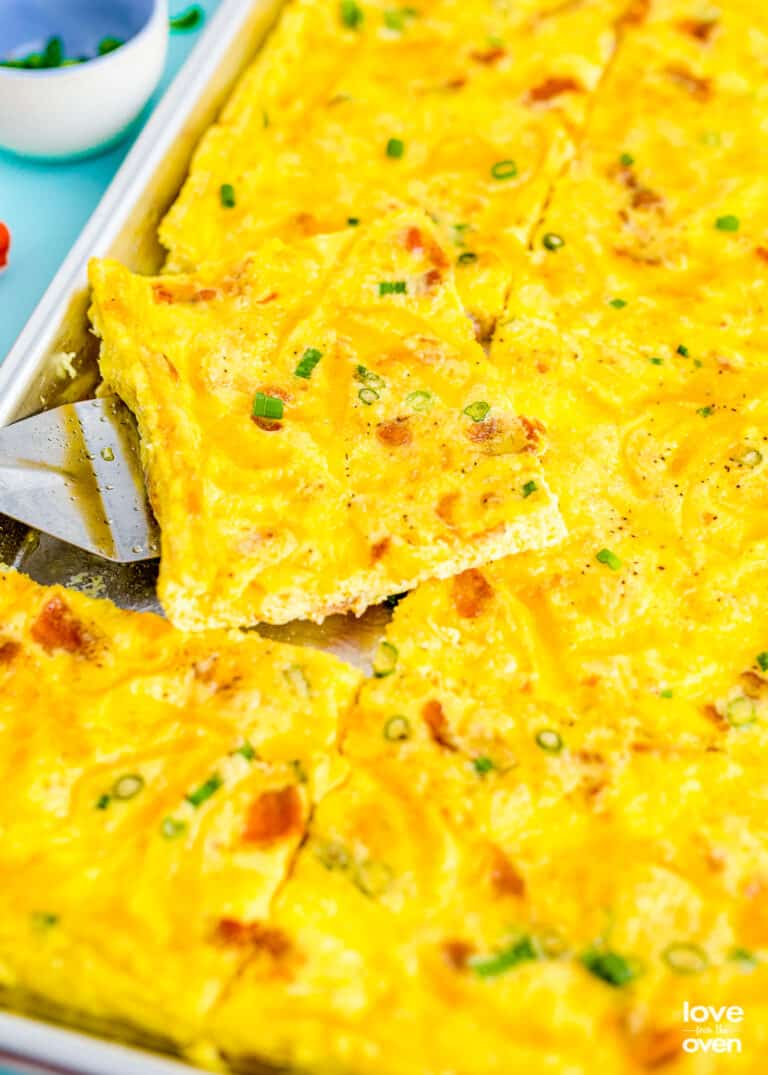 a close up of a spatula picking up some sheet pan eggs