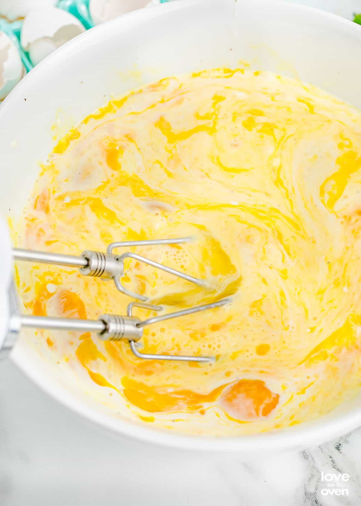 a hand mixer combining the ingredients in a bowl