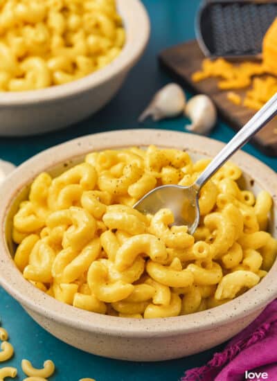 a bowl of butternut squash mac and cheese on a blue background