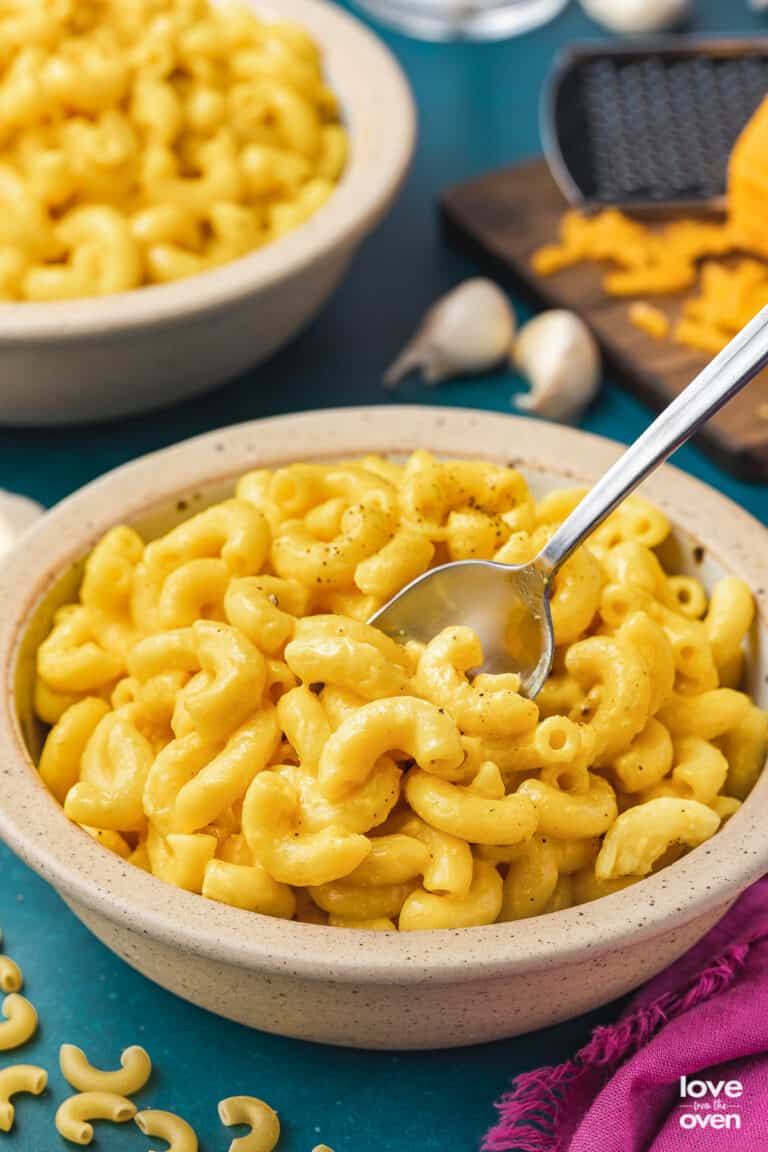 a bowl of butternut squash mac and cheese on a blue background