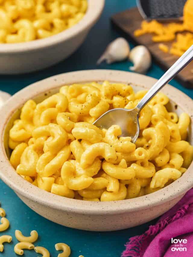a bowl of butternut squash mac and cheese on a blue background