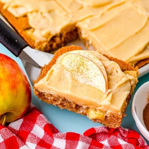 A slice of caramel apple cake being taken out of a pan