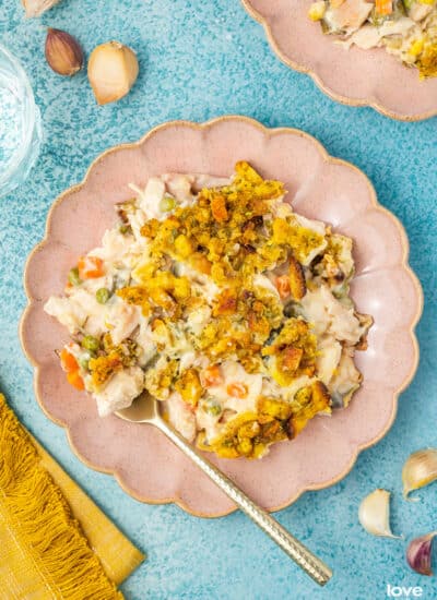 Chicken stuffing casserole on a pink plate on a blue background.