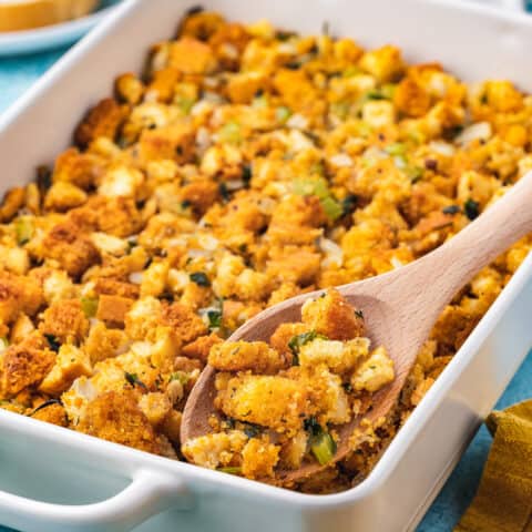 A pan of cornbread stuffing on a blue background