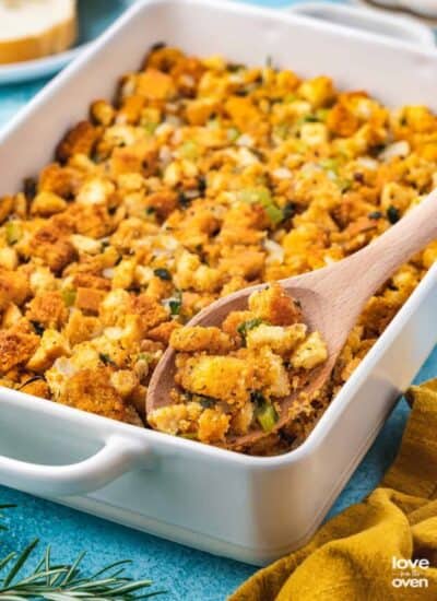 A pan of cornbread stuffing on a blue background