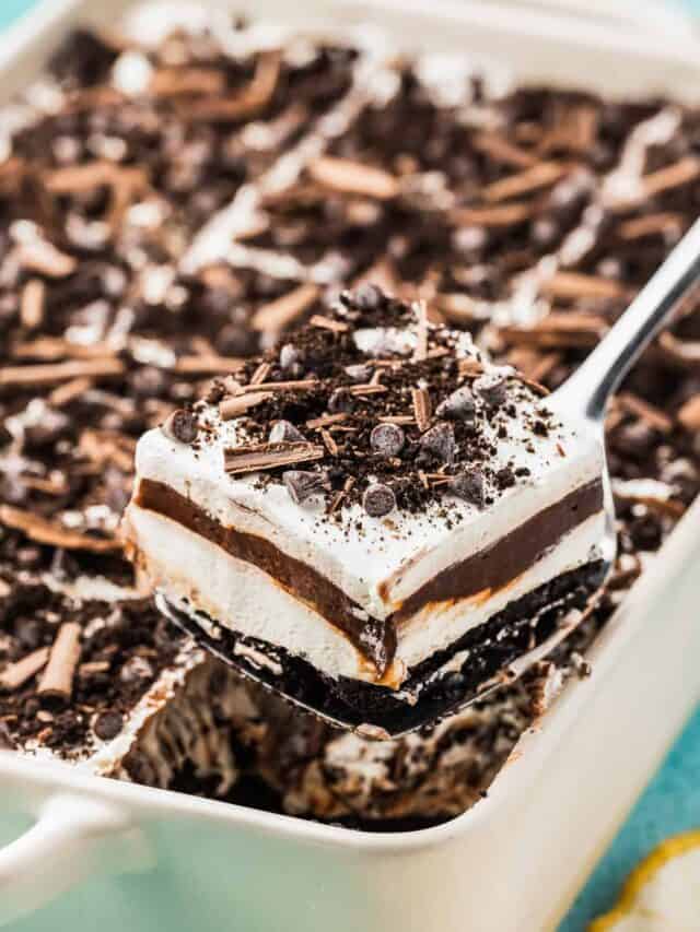 A slice of chocolate lush being taking out of a white pan.