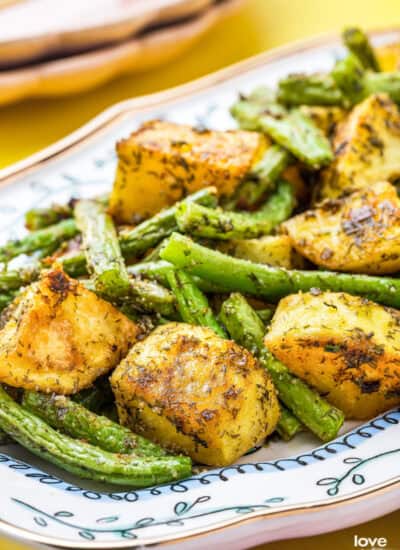 A blue and white dish holding potatoes and green beans