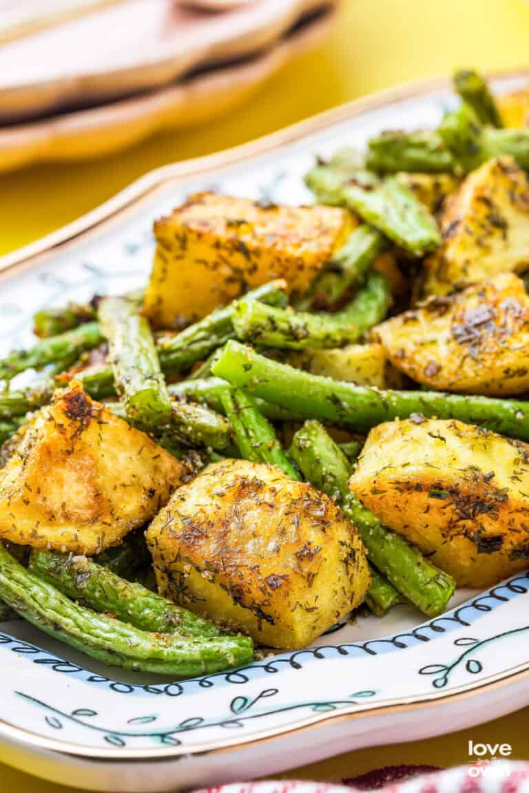 A blue and white dish holding potatoes and green beans