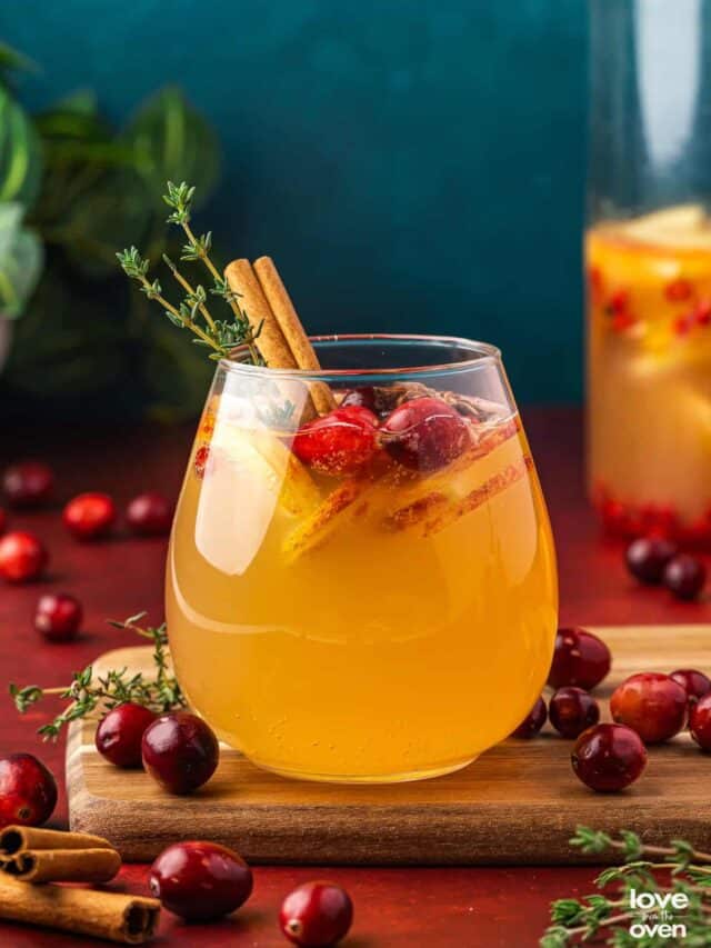 A glass of apple cider sangria with a blue background