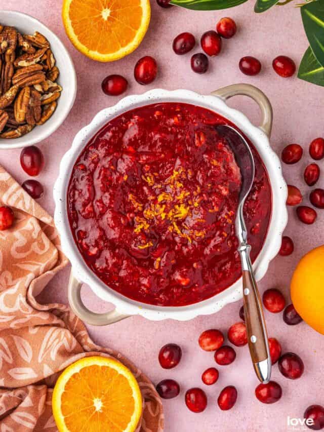 A bowl of cranberry orange relish surrounded by ingredients.