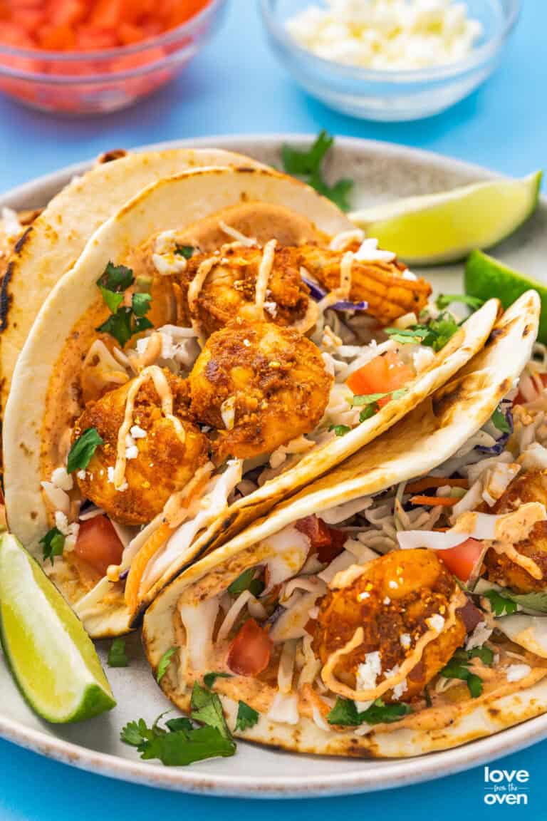 baja shrimp tacos with lime wedges on a plate