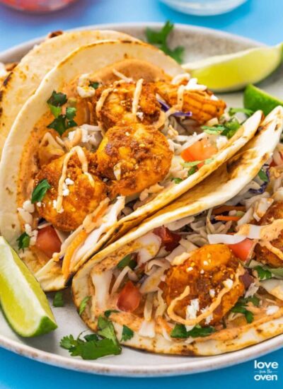 baja shrimp tacos with lime wedges on a plate