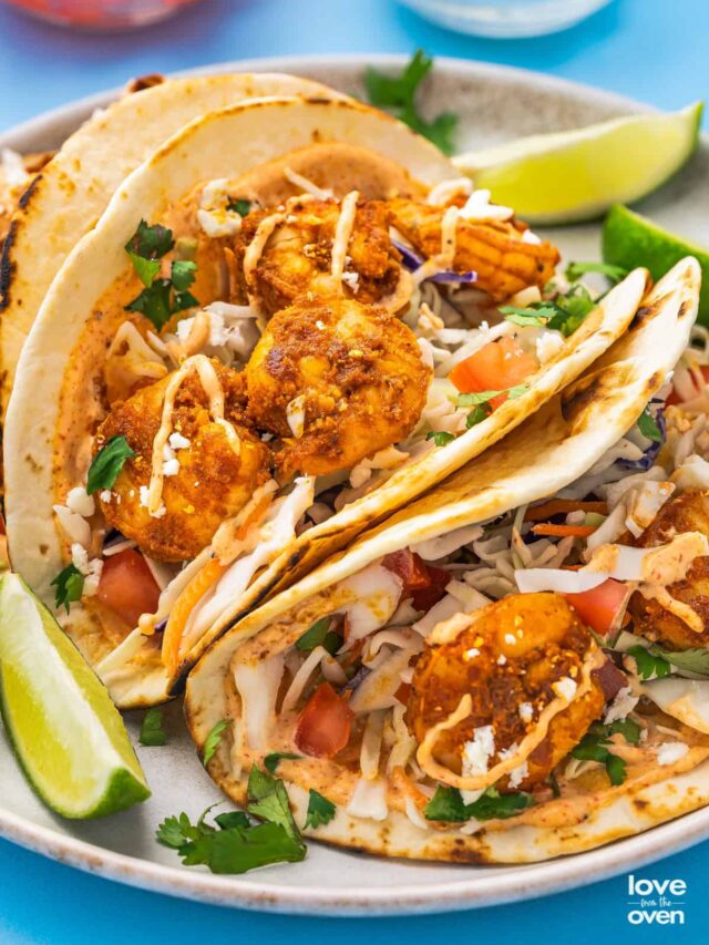 baja shrimp tacos with lime wedges on a plate