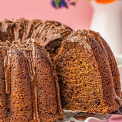 A slice of chocolate pound cake being cut from a cake