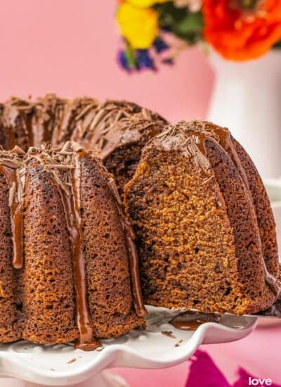 A slice of chocolate pound cake being cut from a cake