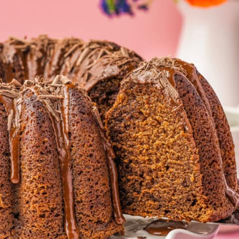A slice of chocolate pound cake being cut from a cake