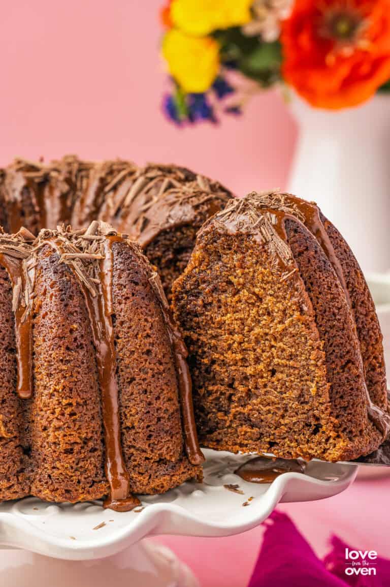 A slice of chocolate pound cake being cut from a cake