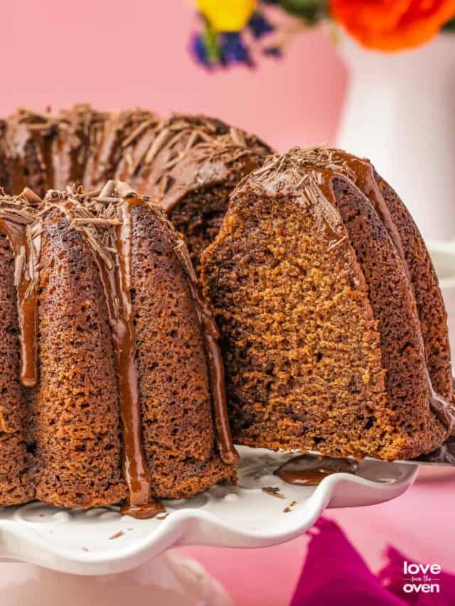 A slice of chocolate pound cake being cut from a cake