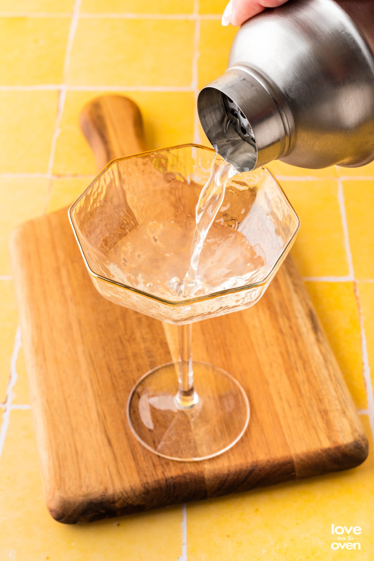 pouring bees knees into a glass