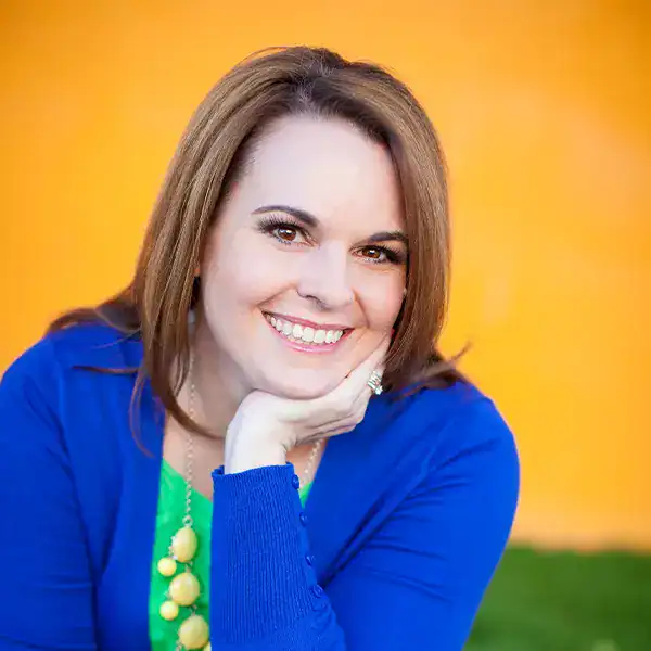 Christi, author of Love From The Oven, wearing a blue sweater and smiling.