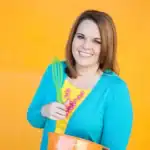 Christi, author of Love From The Oven, smiling holding a whisk.