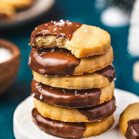A stack of shortbread cookies that have been dipped in chocolate.