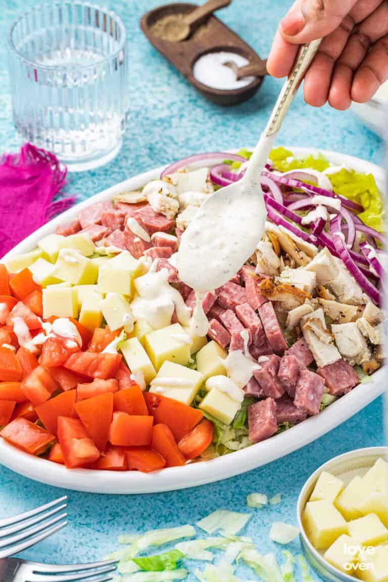 A grinder salad having a drizzle of salad dressing added to it
