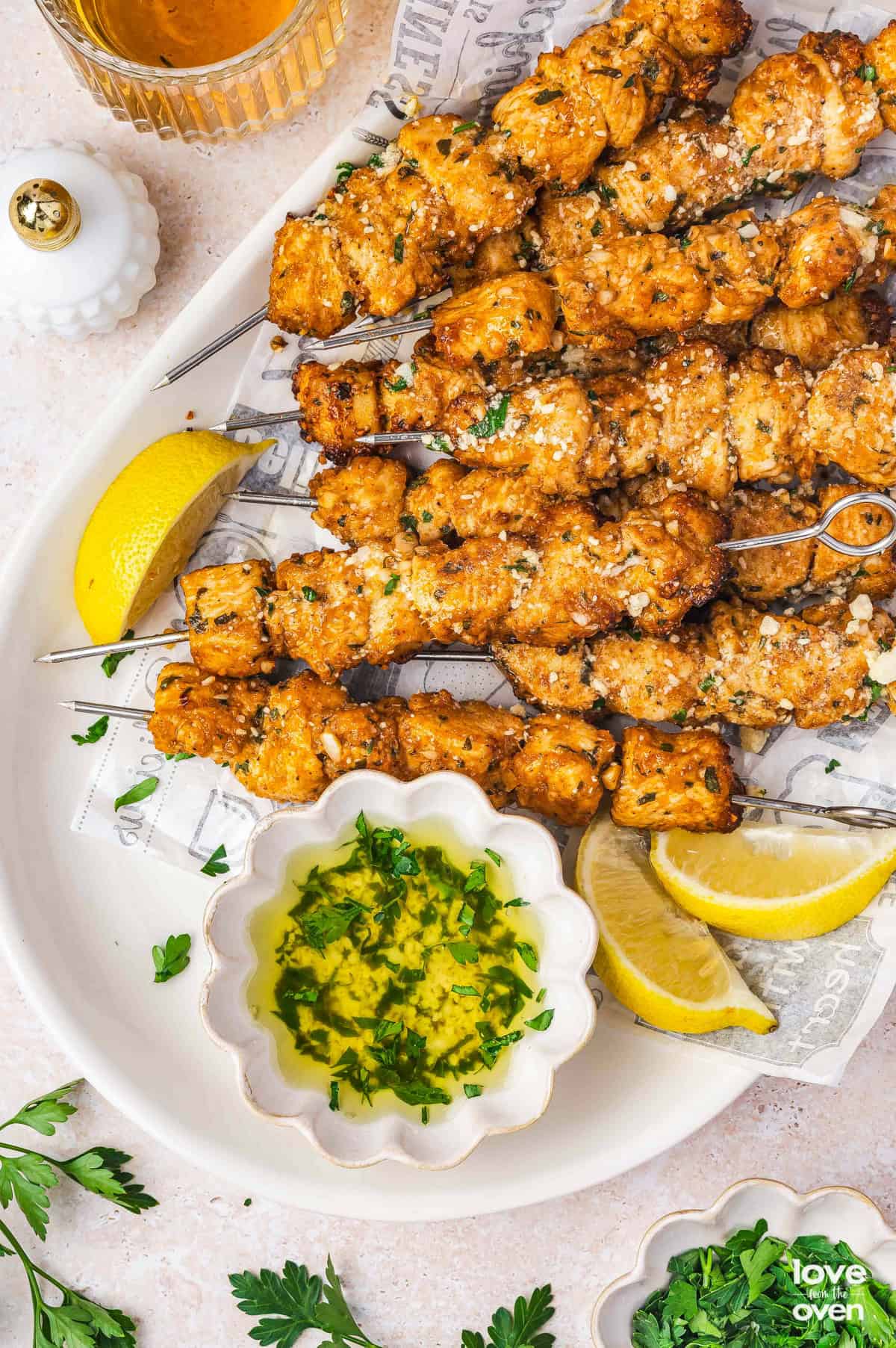 Chicken skewers on a white platter.