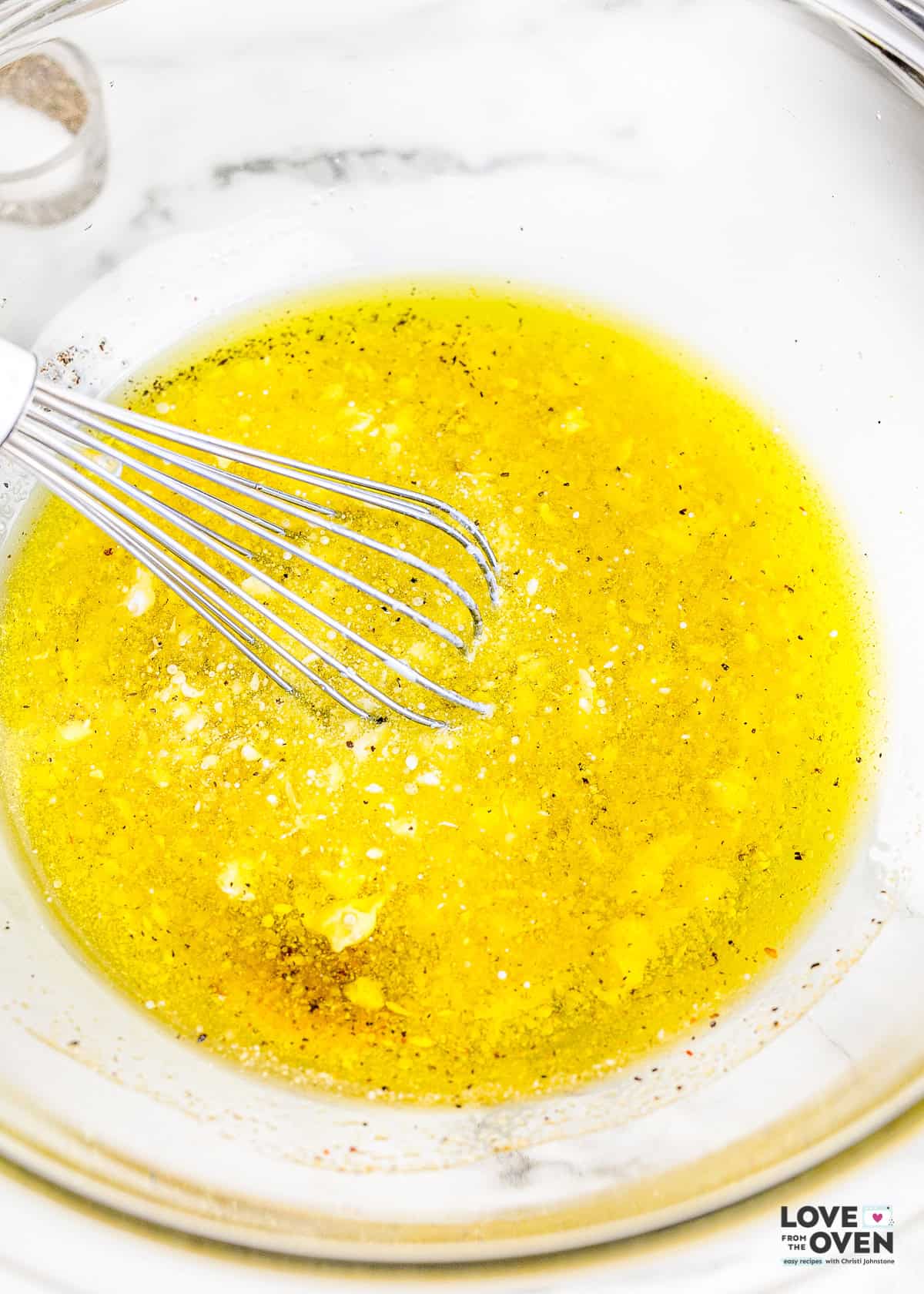 salad dressing being whisked in a bowl