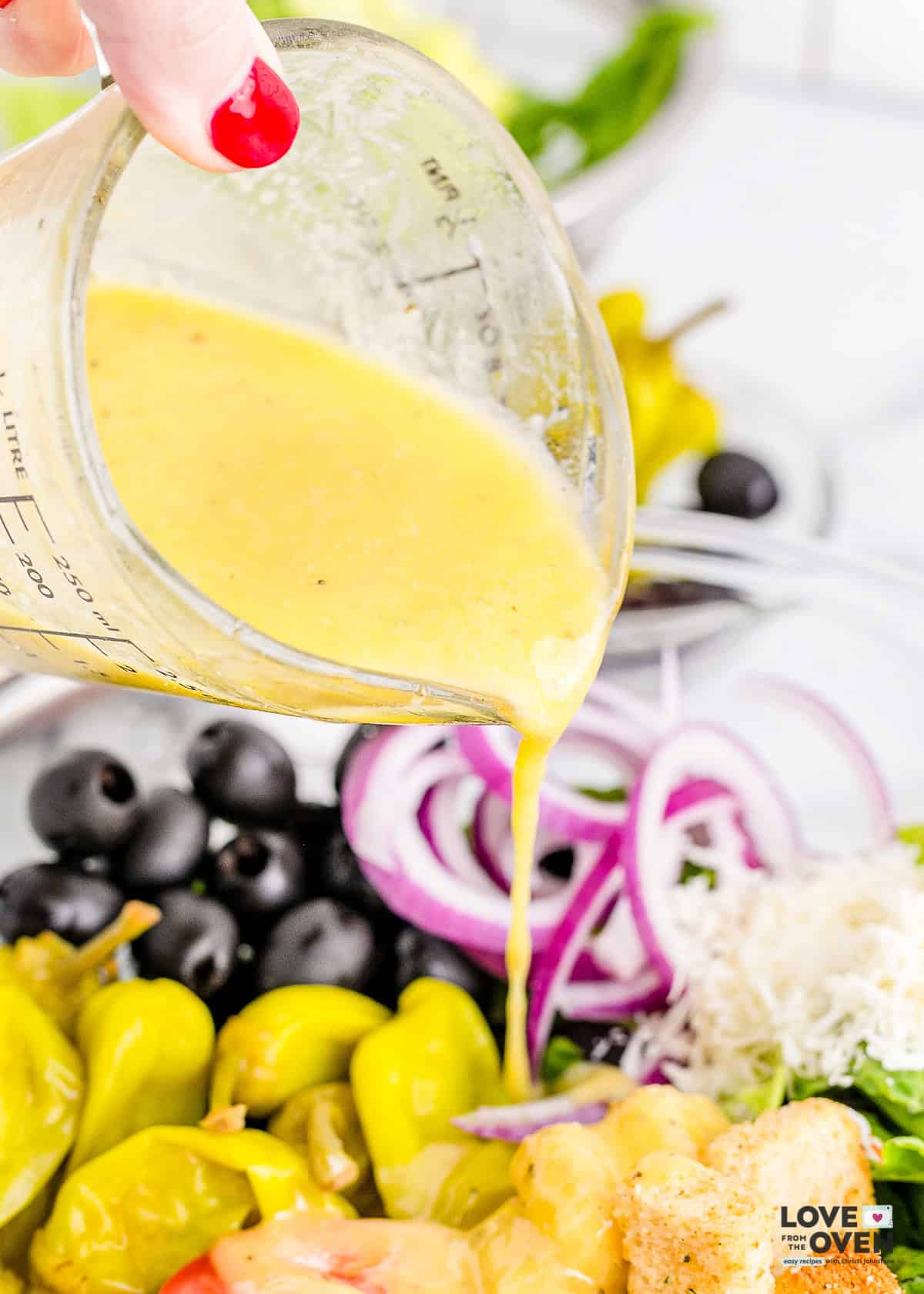 Olive Garden dressing being poured onto a salad