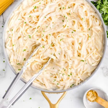 A pan with pasta and Alfredo sauce.