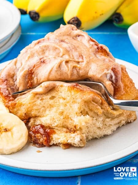 A banana bread cinnamon roll with a fork cutting a piece off