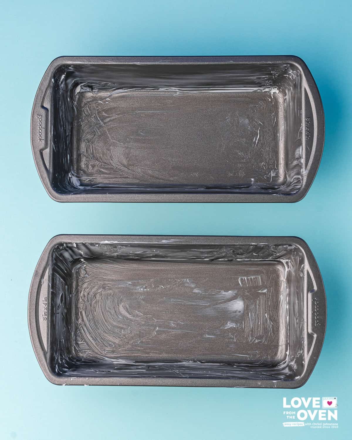 Two bread pans that are greased