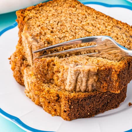 A stack of banana bread slices being cut into with a fork.