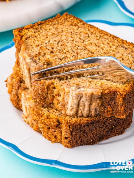A stack of banana bread slices being cut into with a fork.