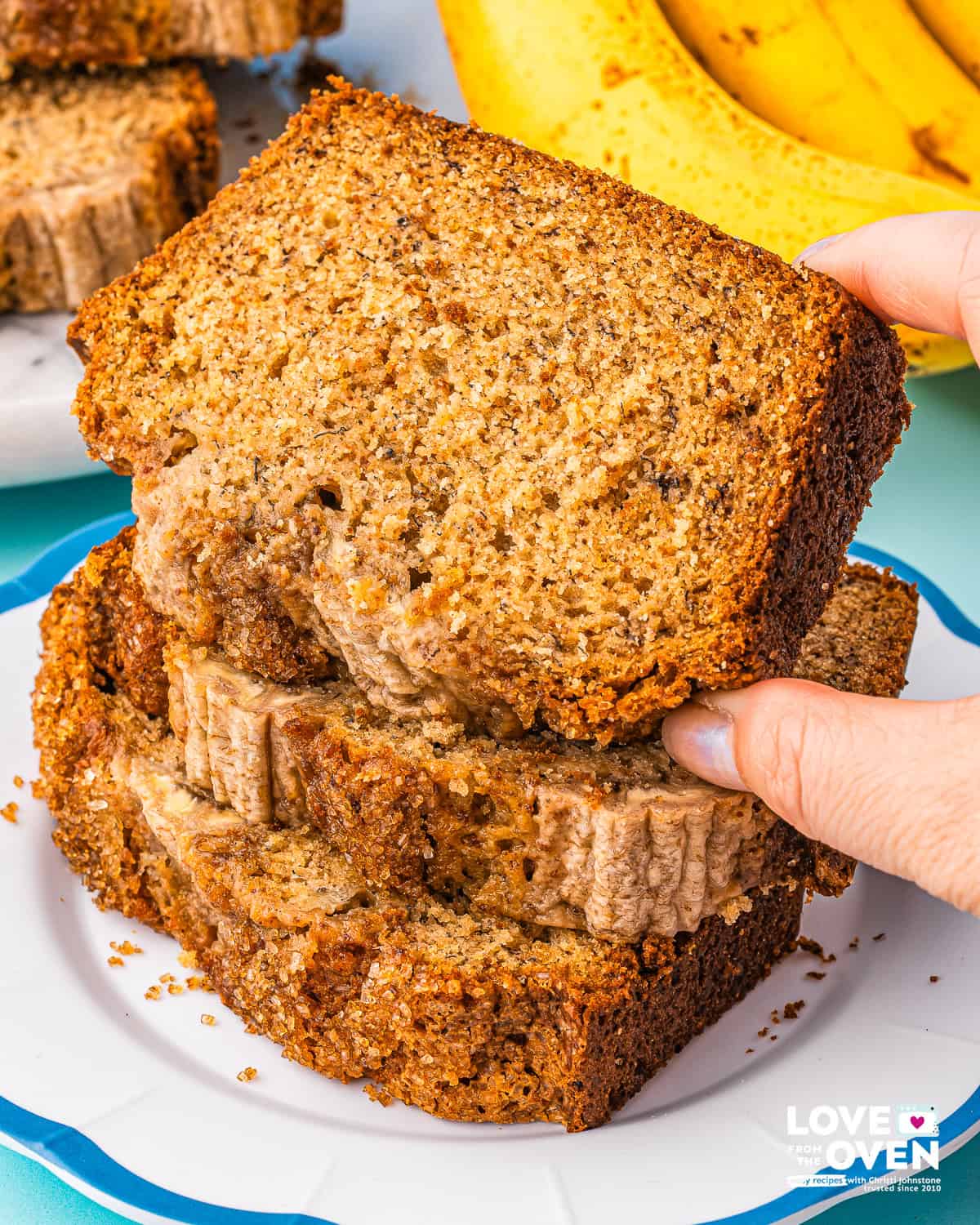 a hand holding a slice of brown butter banana bread